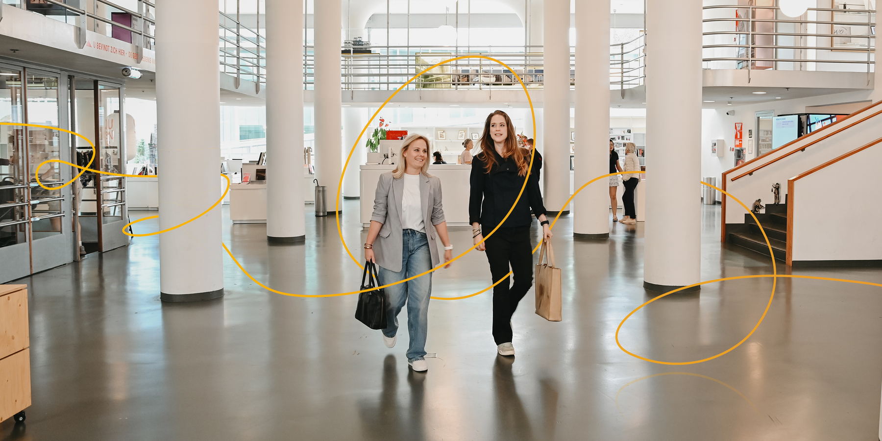 Twee vrouwen lopen door een publieke ontmoetingsruimte